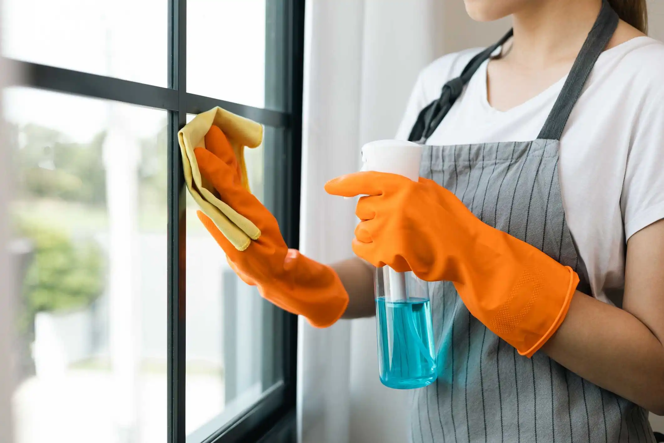 domestic helper wiping window 