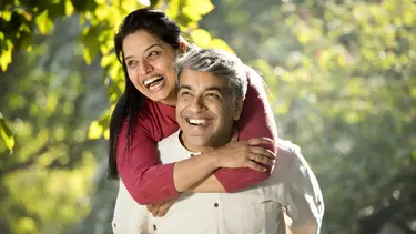 Two people outdoors enjoying a sunny day, symbolizing young seniors planning for retirement, lifestyle protection, and family security.