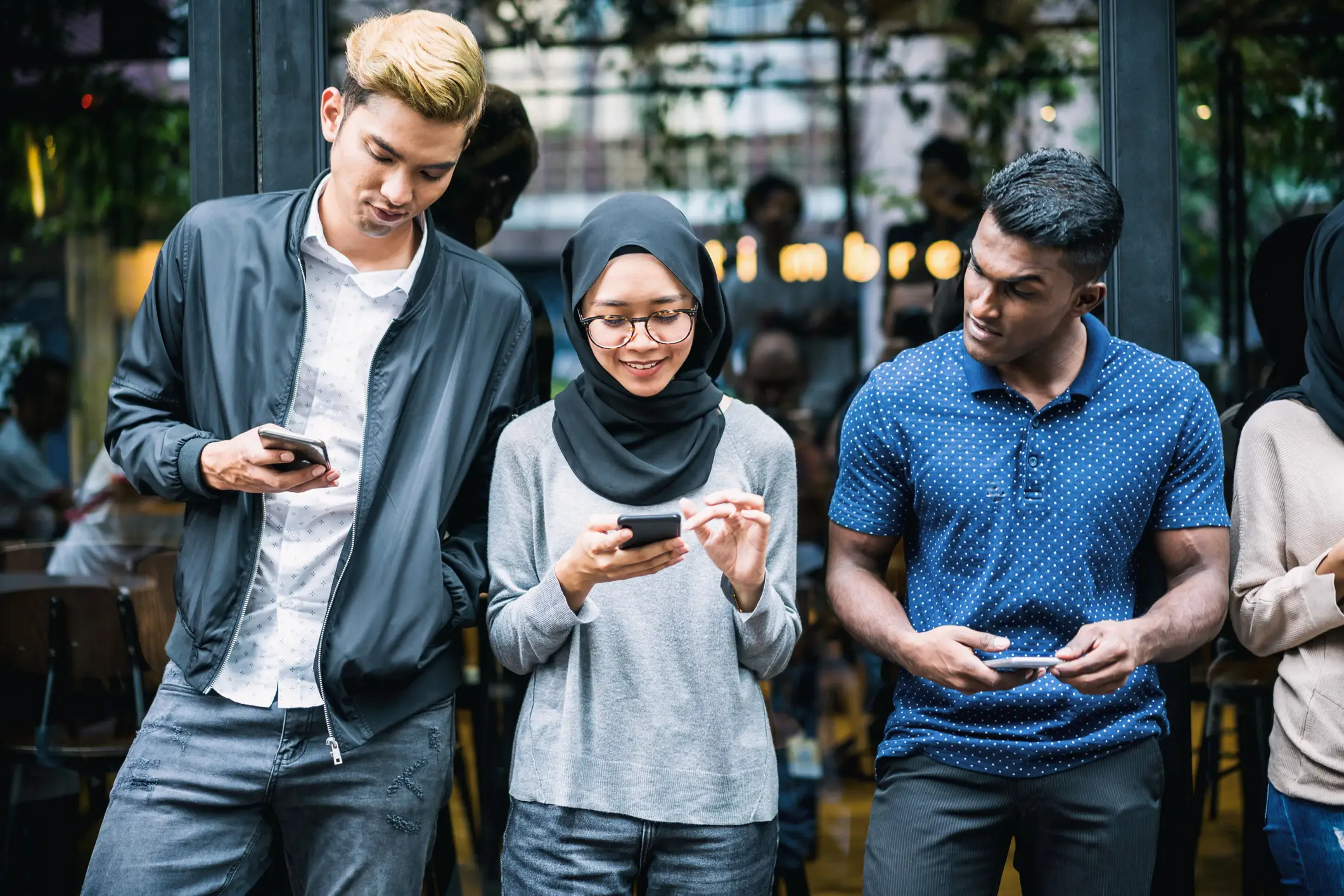 Three people looking at their phones
