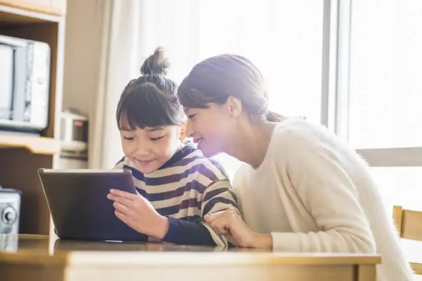 mother and daughter looking into ipad
