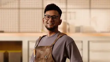 Person standing in a modern workspace, symbolizing working adults planning for financial security, protection, and future milestones like retirement and family.