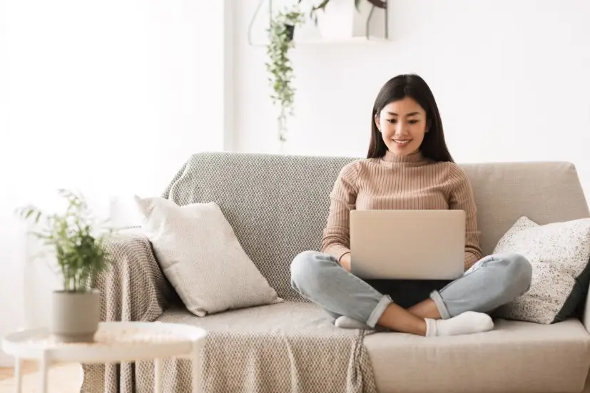 girl using laptop on sofa