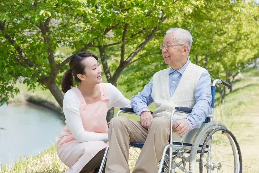 Man in wheelchair with caretaker​