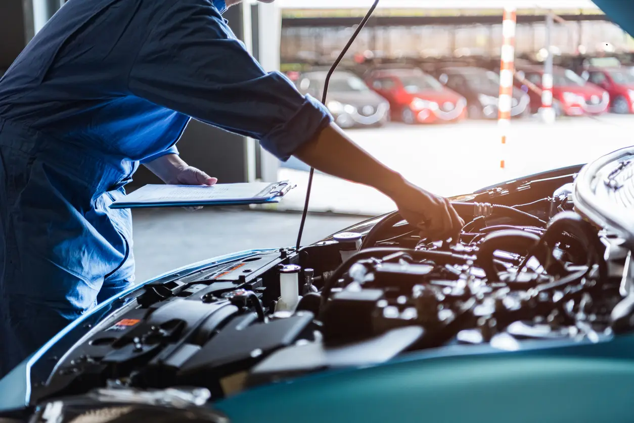 mechanic reaching into car hood