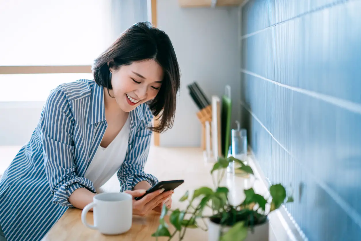 woman looking at phone in kitchen