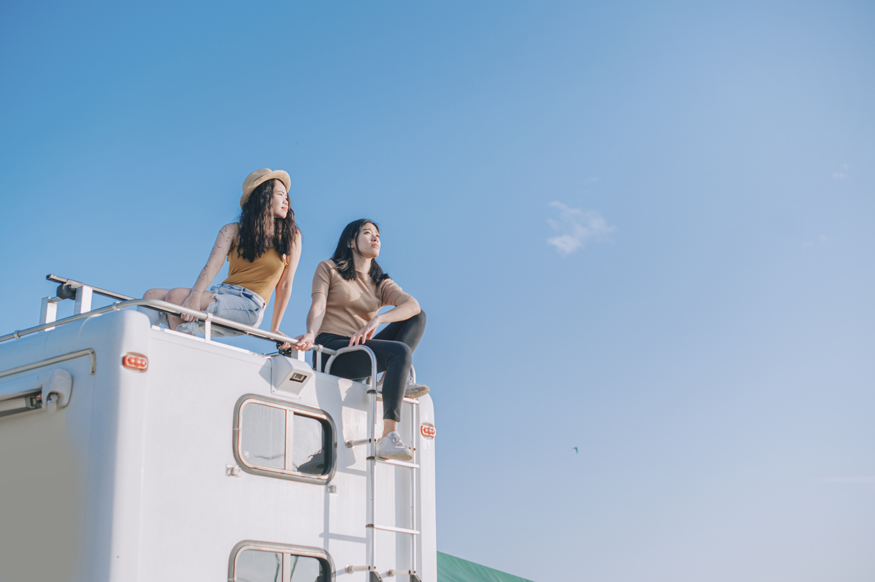 two girls on top of campervan