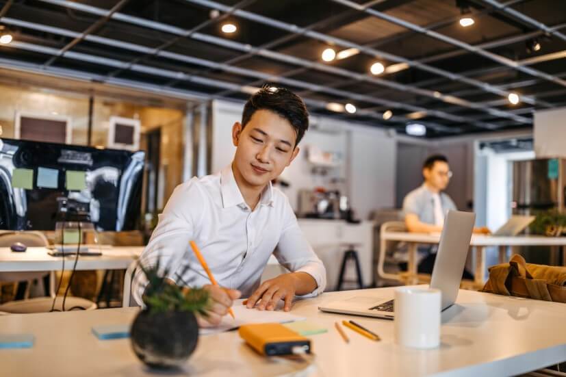 man writing on paper