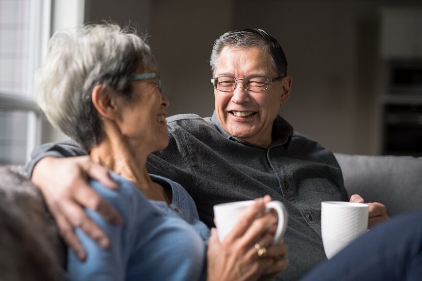 elderly couple enjoying coffee on sofa